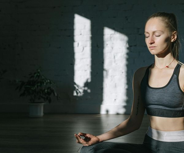 Woman focusing on breathing while sitting in meditation pose.